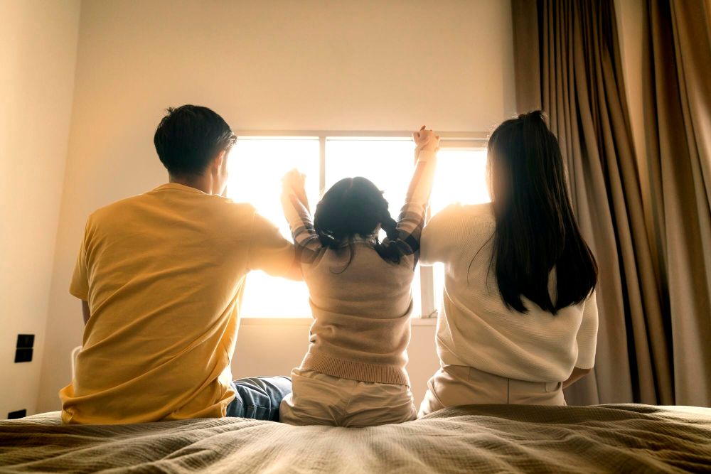 明るい日差しが差し込む住宅内の幸せそうな家族